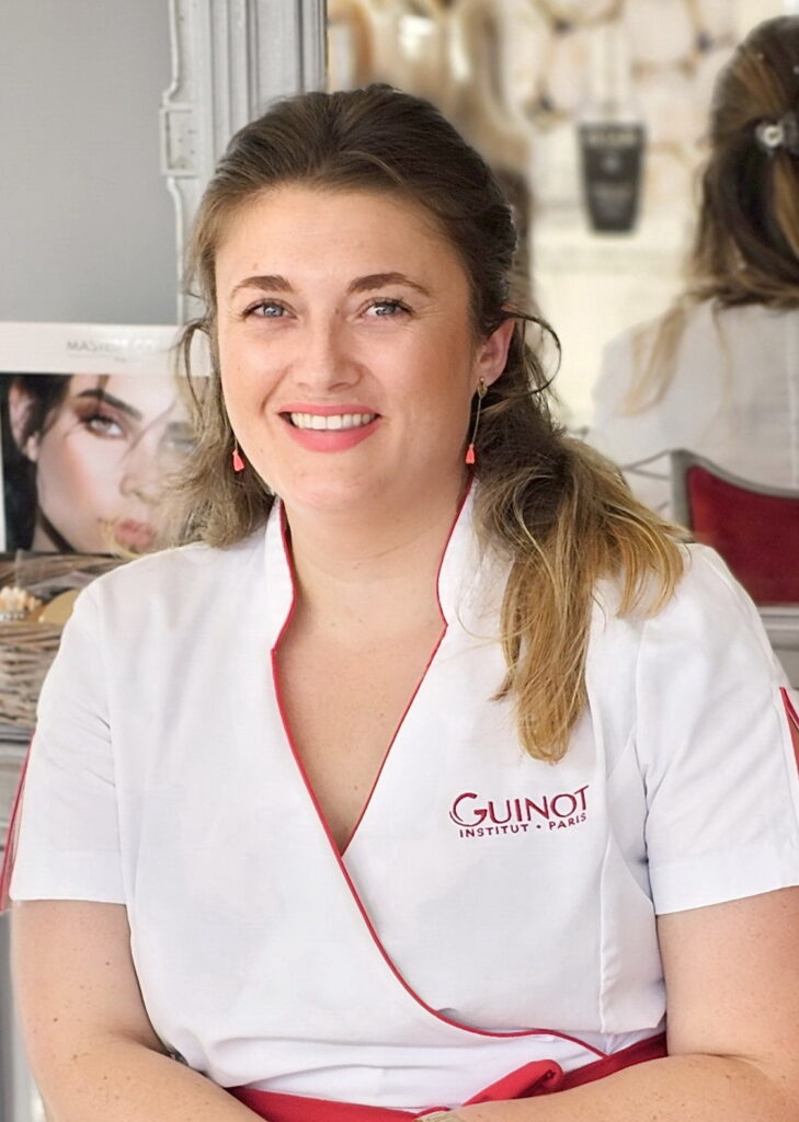 Esthéticienne souriante à l'Institut privilège à Balma, vêtue d'un uniforme.